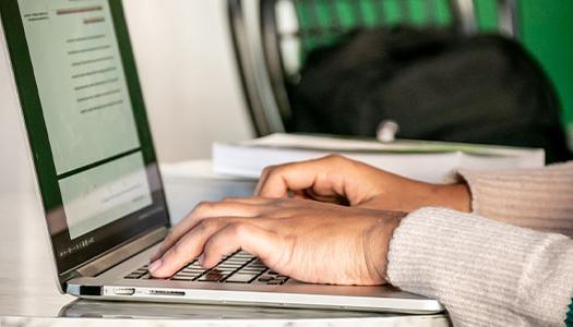 a student types on a laptop